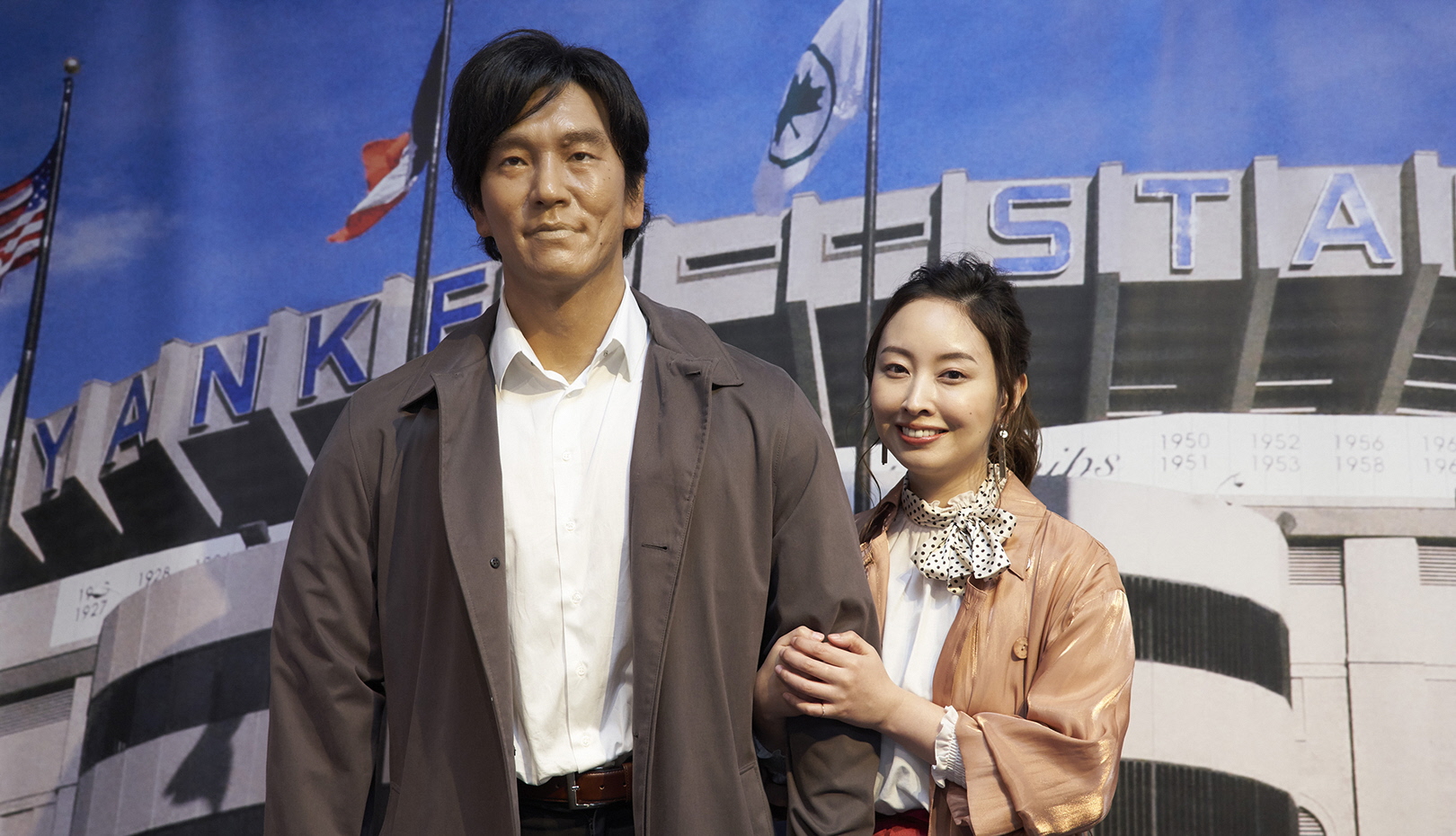 a life-size figure of Mr. Matsui in a trench coat with Yankee Stadium in the background